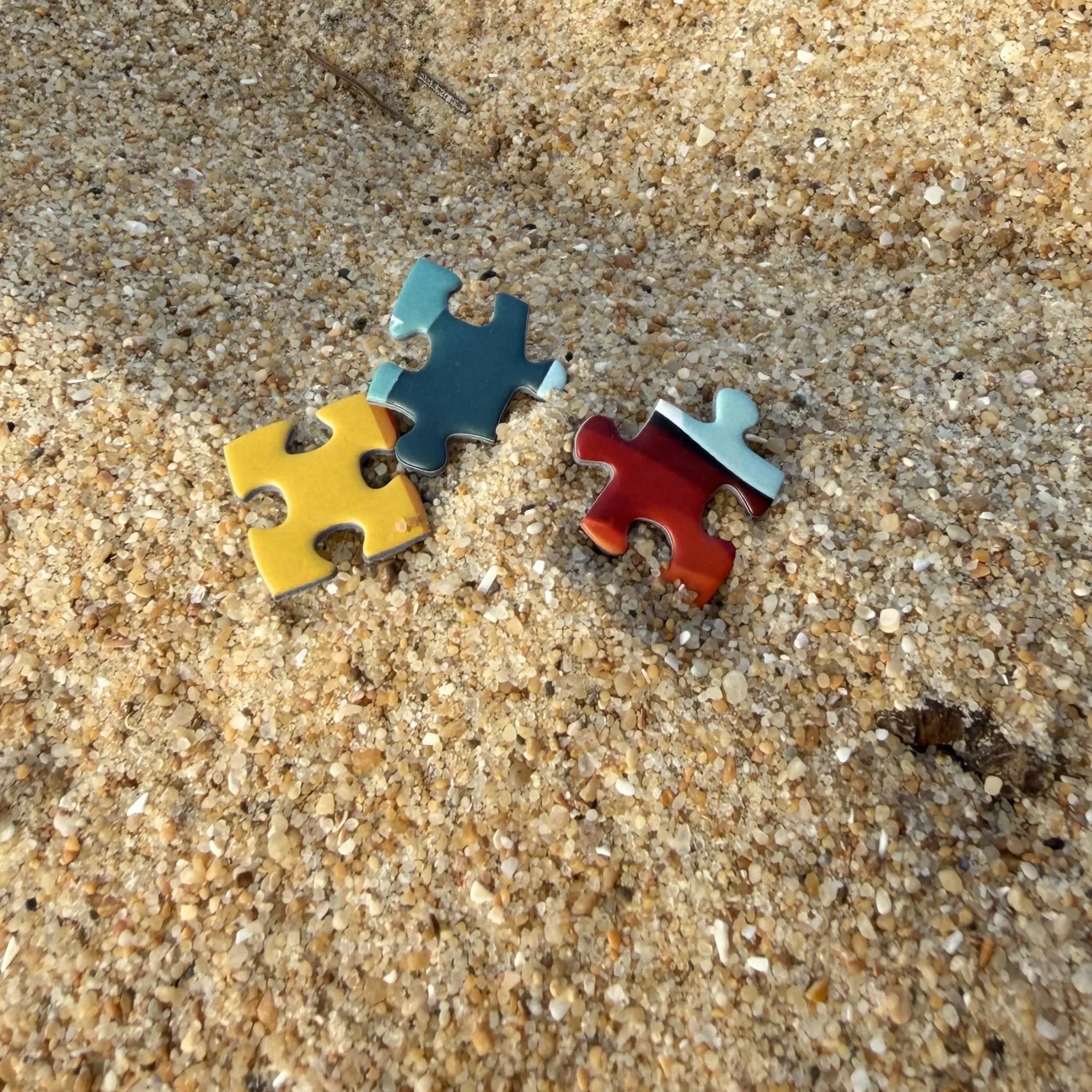 Pièces de puzzle ZEBRESQUE fabriquées en France posées dans le sable sur une plage de la côte landaise dans une ambiance slow life inspirée du surf, de l’océan et des moments calmes sans écran