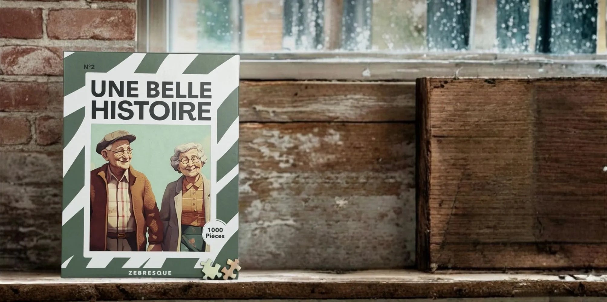 Boîte du puzzle adulte 1000 pièces “Une belle histoire” de ZEBRESQUE représentant un couple de seniors souriant, posée près d’une fenêtre dans une ambiance vintage chaleureuse et nostalgique.