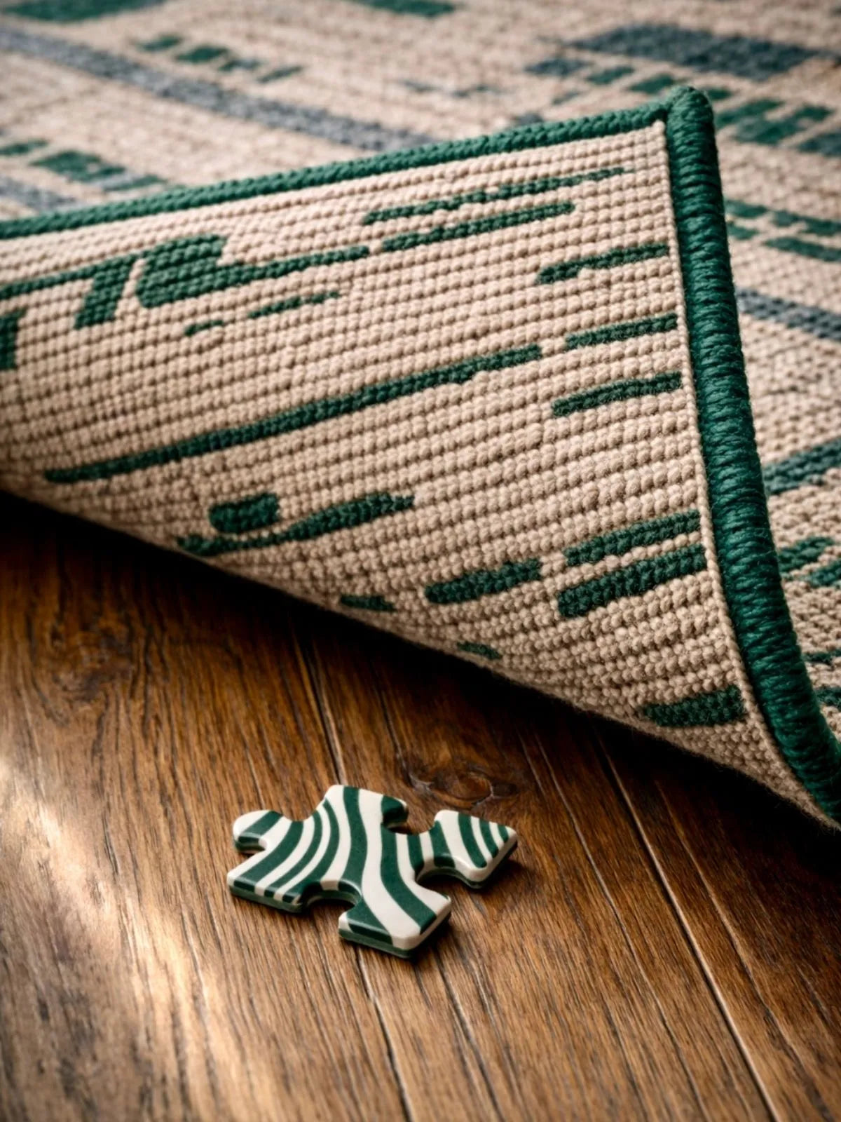 Pièce de puzzle 1000 pièces adulte ZEBRESQUE fabriqué en France motif rayures vert foncé perdue sous un tapis sur un parquet en bois