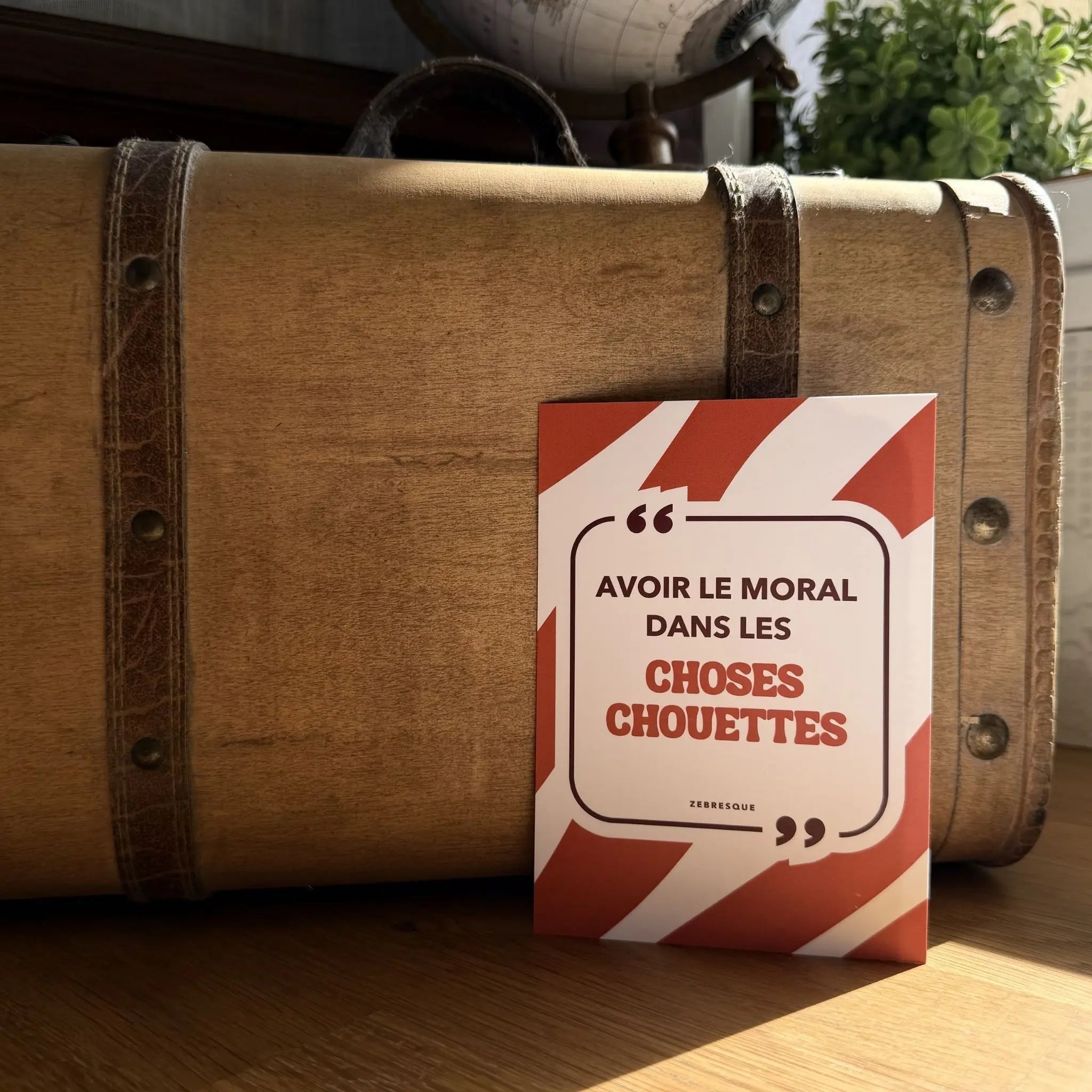 Carte postale haut de gamme ZEBRESQUE “Avoir le moral dans les choses chouettes” photographiée dans une ambiance éditoriale chaleureuse. Papeterie créative française au design singulier et à l’humour sensible.