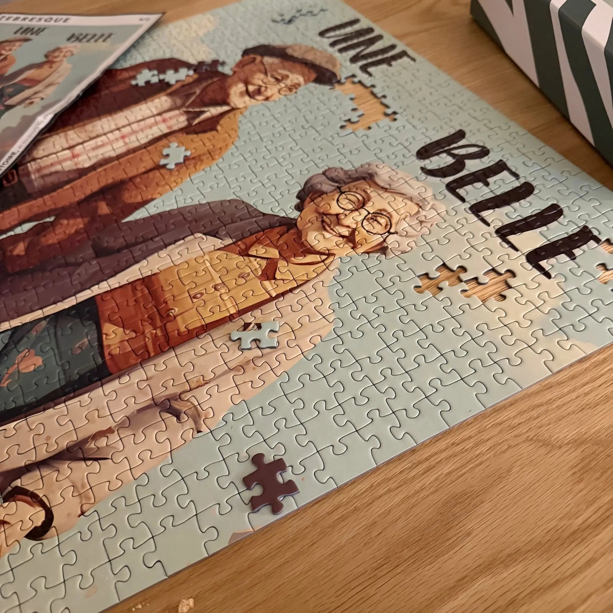 Détail du puzzle adulte 1000 pièces “Une belle histoire” de ZEBRESQUE avec illustration d’un couple âgé dans une ambiance douce et nostalgique. Un puzzle poétique fabriqué en France pour les amateurs de moments calmes et créatifs.