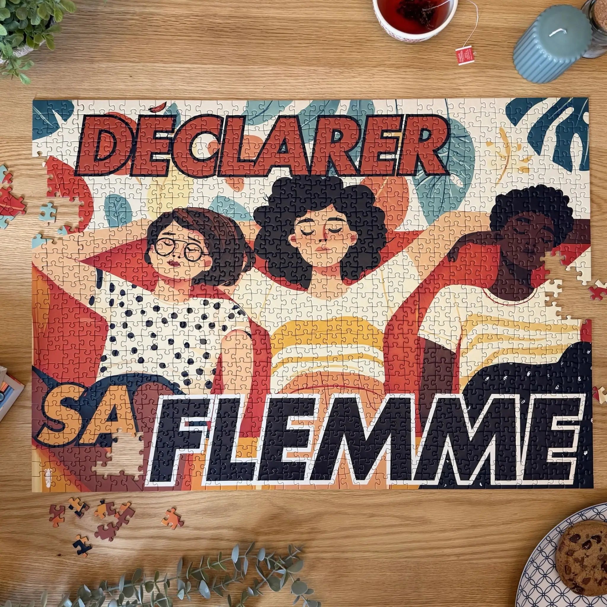 Puzzle adulte 1000 pièces ZEBRESQUE “Déclarer sa flemme” entièrement assemblé sur une table en bois avec thé, cookies et ambiance cosy slow life invoquant la déconnexion et la pause volontaire. 